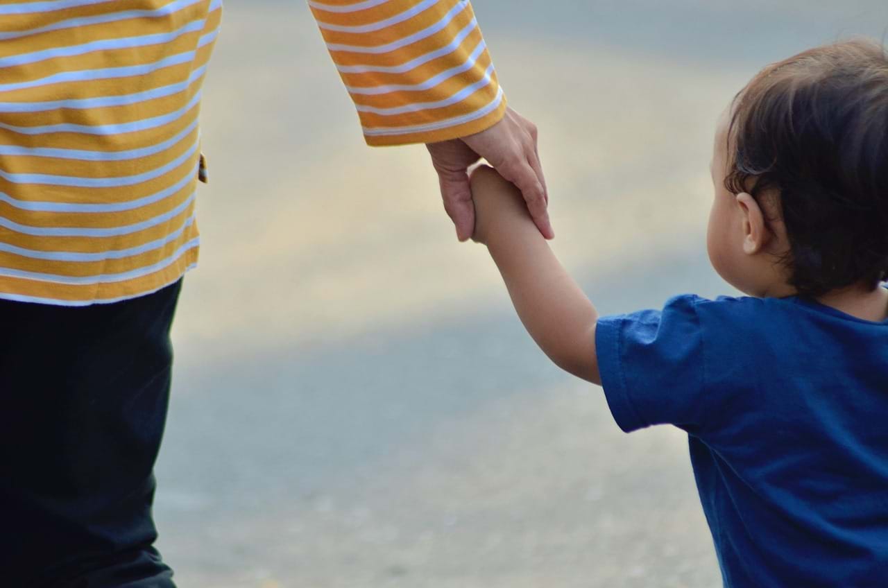 parent and child hold hands, facing the world and challenges together as a team